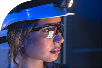 Profissional industrial com capacete e óculos de segurança em ambiente de operação